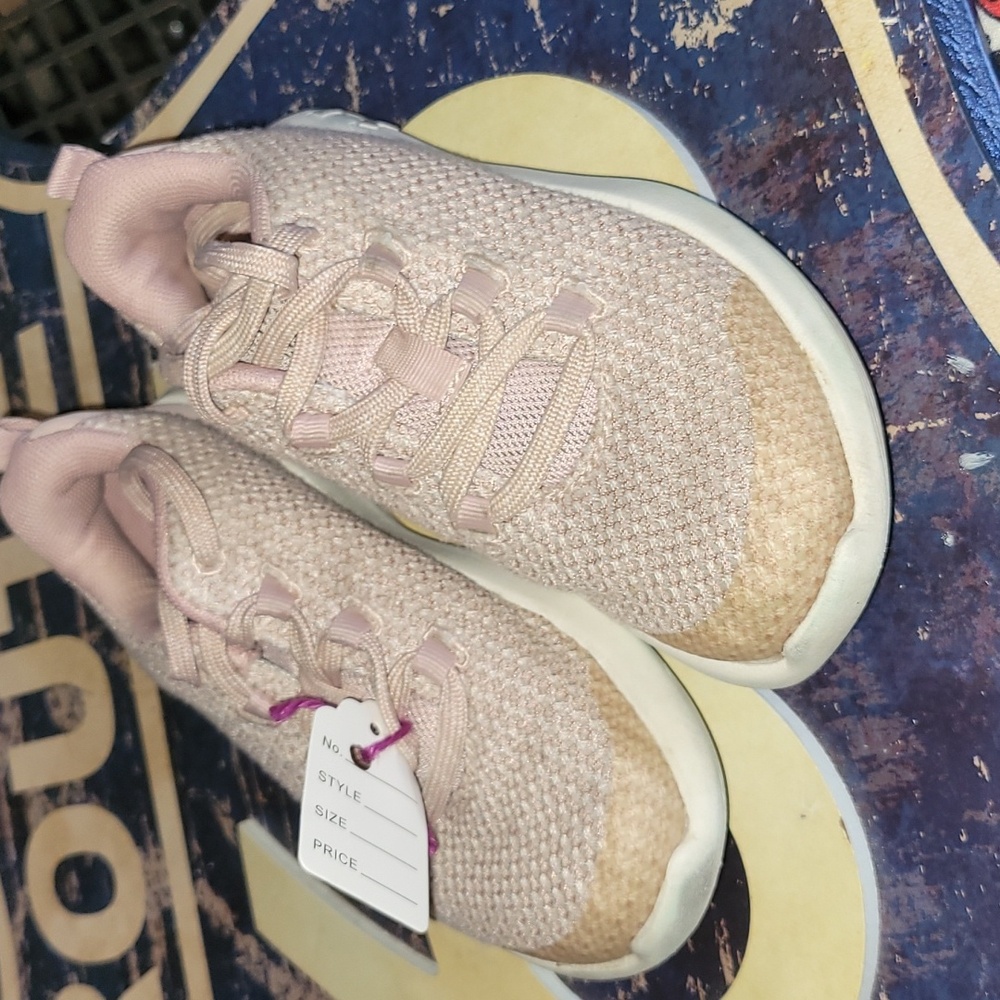 Girls pale pink Under Armour shoes.